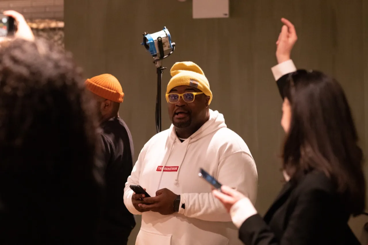 The director gives notes to cast and crew between takes.